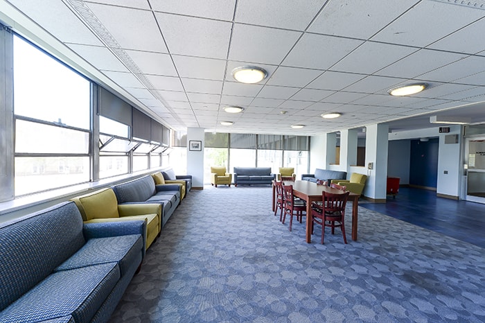 Donner House Main Floor Lounge - blue and green couches, a table and lots of windows